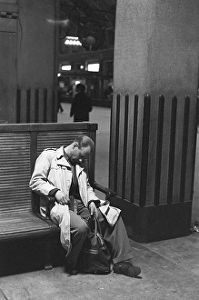 Stockholm Central Station in 1954. The large central hall is where everyone passes from and to the trains. A man has fallen asleep sitting on one of the benches, still with his hand around the handle of his bag. Kristoffersson ref 1-12