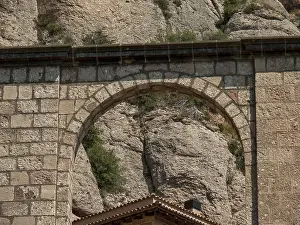Stone arch in front of a rocky mountain backdrop