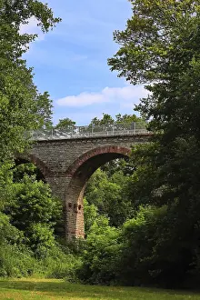 Stone viaduct spans green, wooded landscape near Eichelberg
