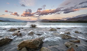Stones on shore, lake with sunset swell