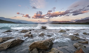 Stones on shore, lake with sunset swell