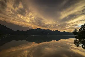 Stormy atmosphere, mountains reflected in lake