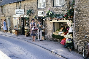 Stow on the Wold, Gloucestershire, England 1963 Woman and boy posing in front of a fruit shop in Cotswold