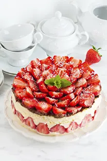 Strawberry cake Fraisier on the white plate and cups for teatime