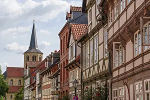 Street with half-timbered houses and church tower on the horizon