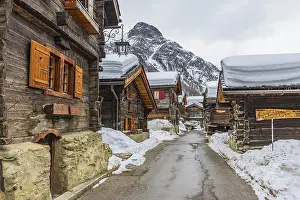 Street with historic old snow-covered wooden houses