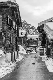 Street with historic old snow-covered wooden houses