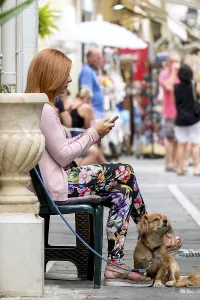 Street scene with woman and dog and mobile phone in the old town of Rethymno