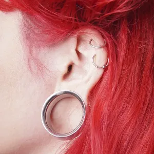 Stretched earlobe piercing with flesh tunnel