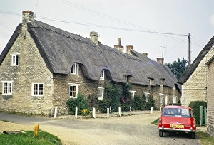 Strohgedeckte Haeuschen in der Crocket Lane, Dorf Empingham, Rutland, England, Vereinigtes Koenigreich August 1972 Roter Austin Morris 1100 Mk 2