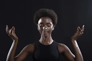 Studio portrait of african american female model showing zen yoga mudra or okay sign gesture