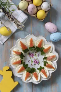 Stuffed eggs with cheese and salted salmon in the form of a carrot on a wooden table