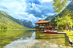 Stunning view of lake dobbiaco with pedal boats and a restaurant