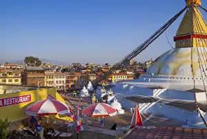 A stupa in the city center with a restaurant in the foreground