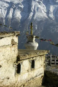Stupa and prayer flags, Gompa Monastery in front of snowy mountain slope