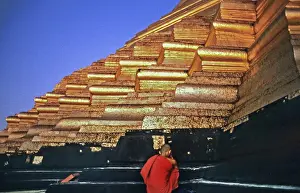 Stupa and praying monk on the top step of Shwedagon Pagoda