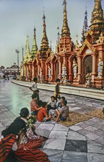 Stupas, children and praying woman on the Shwedagon Pagoda
