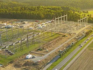 Substation under construction, surrounded by green fields and forests