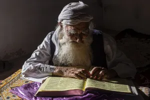 Faces Of The World Prints: Sufi priest studying the holy Quran in the Shrine of Mawlana Abdur Rahman Jami