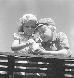 Summer in the 1950s. Two children are sharing one icecream