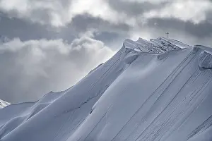 Summit cross of the Hoeferspitze with covered summit ridge