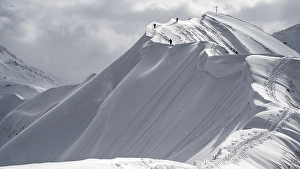 Summit cross of the Hoeferspitze with covered summit ridge and mountaineers