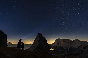 Summit of the Sonnenspitze with mountaineer and tent as well as Zugspitze in the background with blue hour