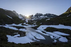 Sun over lake Isvatnet with ice