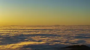 The sun rises over a cloud cover