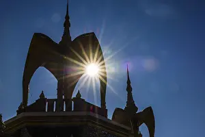 The sun shines through a round arch pavilion