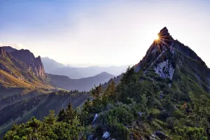 Sun star on Choepfenberg, mountain landscape at sunset