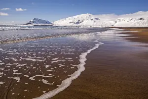 Sunny winter day on the sandy beach in front of Snaefellsjoekull volcano