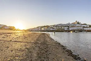 Sunrise on the Atlantic, skyline of a fishing village behind a harbour