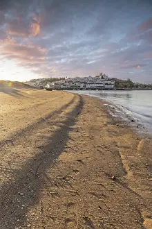 Sunrise on the Atlantic, skyline of a fishing village behind a harbour