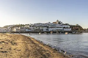Sunrise on the Atlantic, skyline of a fishing village behind a harbour