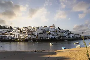Sunrise on the Atlantic, skyline of a fishing village behind a harbour