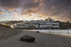 Sunrise on the Atlantic, skyline of a fishing village behind a harbour