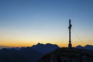 Sunrise with cross of the Thanell summit and Lechtal Alps