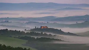 Sunrise with foggy atmosphere in the hilly landscape