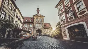 Sunrise through the gate of a historic building in a European old town