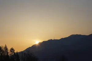 Sunrise over hill range and transmission tower