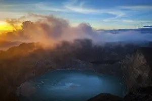 Sunrise at Kelimutu Volcano, fog over crater with crater lake