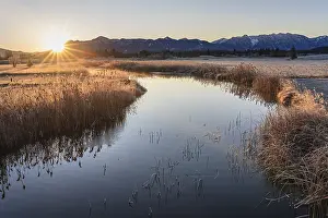 Sunrise on a quiet river in front of mountains