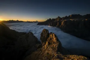 Sunrise over a sea of fog and Dolomite peaks in the background