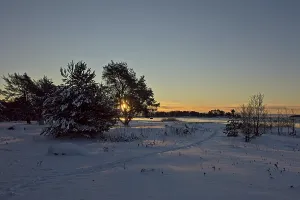 Sunrise at seashore on a cold winter day with snow covered ground