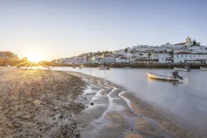 Sunrise with view over a beach and harbour basin at low tide
