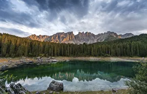 Sunset, dramatic clouds, Latemar group reflected in the Karersee