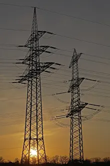 Sunset behind high-voltage pylons