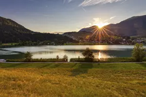Sunset over a lake with mountains and meadows