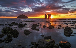 Sunset behind rock formation on the beach of Mosteiros on the west coast of Sao Miguel, Azores, Portugal, Europe
